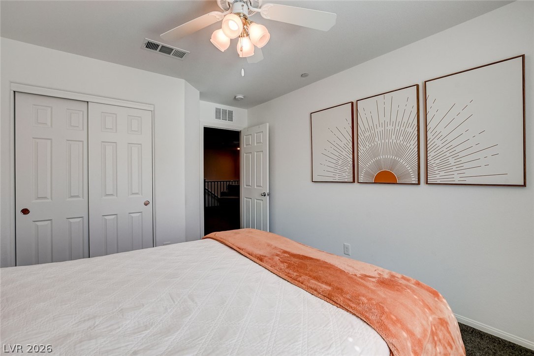 484 Filaree Place Henderson, NV 89015 - Photo 37 of 71 This bright bedroom features a ceiling fan, closet, and carpeted flooring, perfect for relaxation.