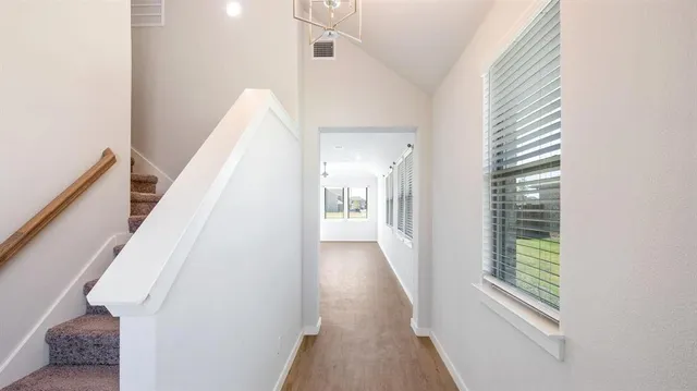 a view of a hallway with wooden floor and staircase