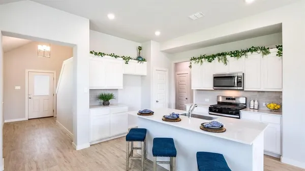 a kitchen with a sink a stove and chairs