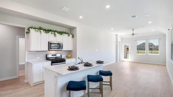 a open kitchen with stainless steel appliances granite countertop a sink stove and refrigerator with wooden floor