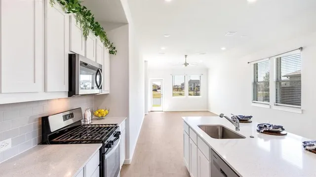a kitchen that has a sink and a stove in it