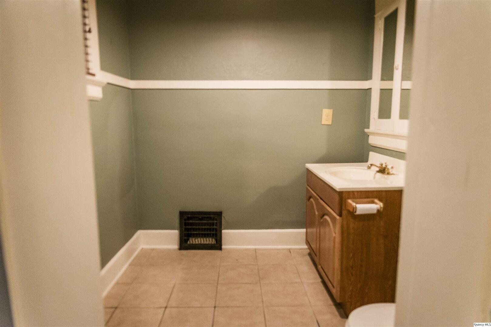 424 South 8th Street Quincy, IL 62301 - Photo 8 of 9 a bathroom with a sink a vanity and a toilet