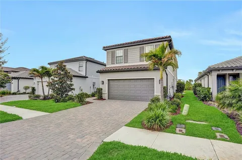 front view of a house with a yard and an trees