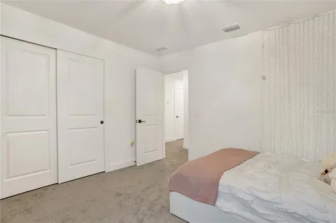 a bedroom with a large bed and a chandelier