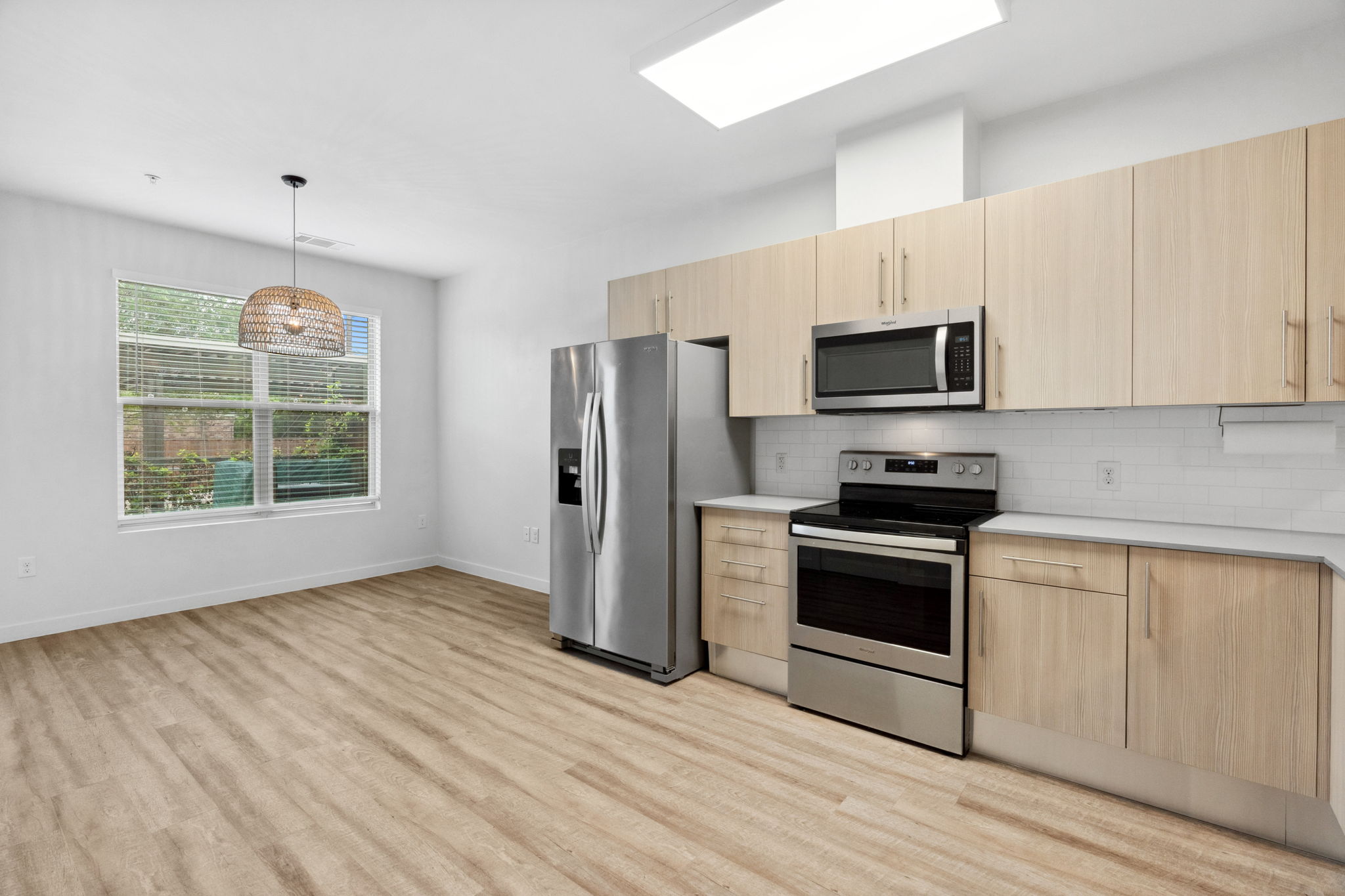 7805 Cooper Lane, Unit 606 Austin, TX 78745 - Photo 6 of 35 a kitchen with stainless steel appliances a stove a microwave oven cabinets and a wooden floor