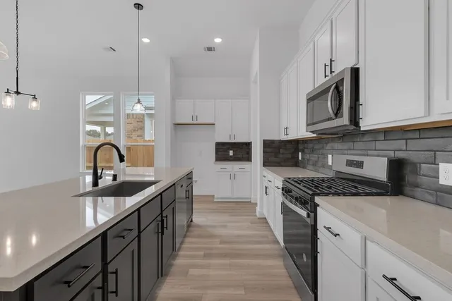 a kitchen with stainless steel appliances granite countertop a sink and stove