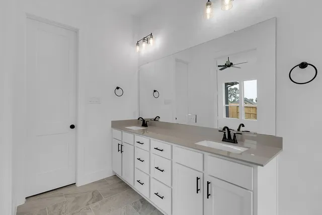 a bathroom with double sink and a mirror