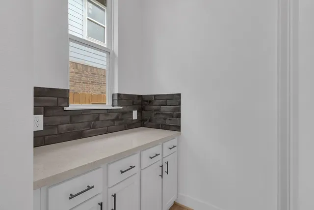 a kitchen with granite countertop white cabinets and a window