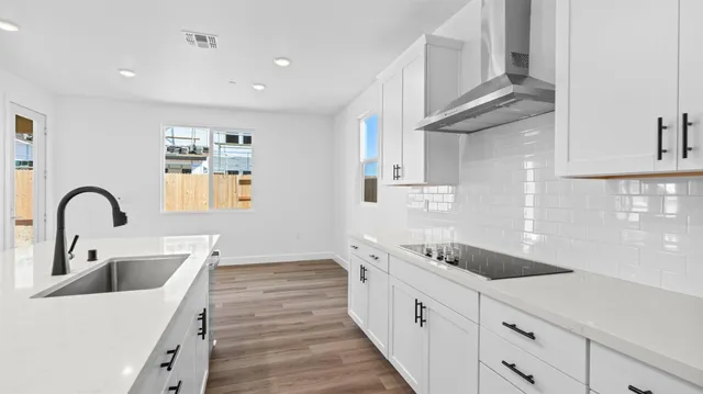 a kitchen with stainless steel appliances granite countertop a sink and dishwasher a stove with wooden floors