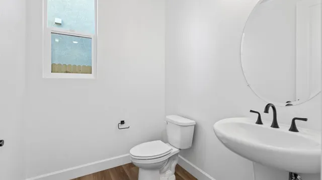 a bathroom with a sink mirror and toilet