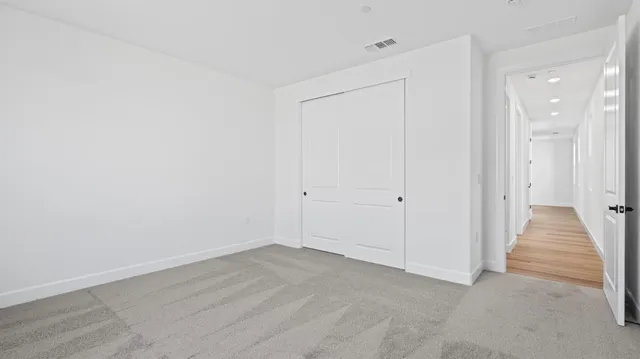 a view of a hallway with wooden floor and entryway