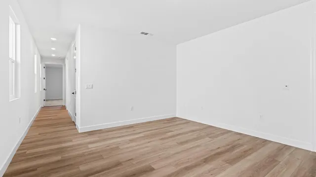 a view of a hallway with wooden floor