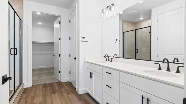 a bathroom with a double vanity sink mirror and shower