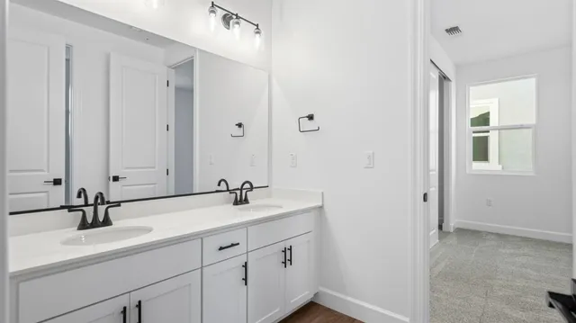 a bathroom with double vanity sink and a mirror
