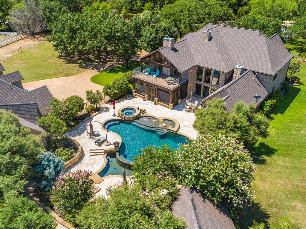 an aerial view of a house with swimming pool and a yard