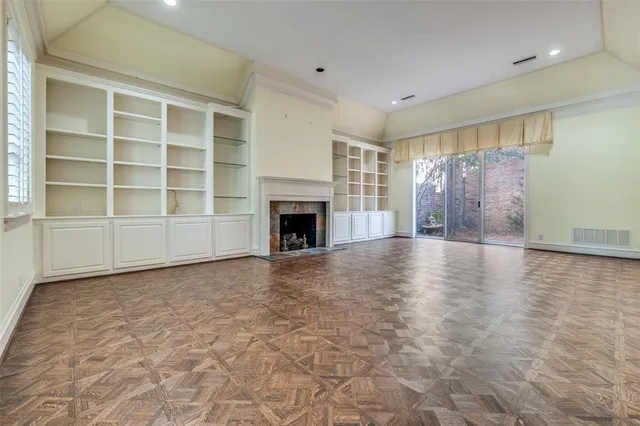 a view of an empty room with a fireplace and a window