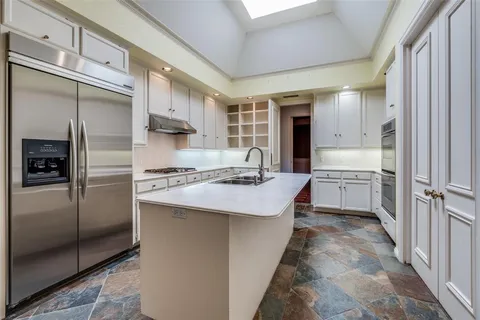 a kitchen with kitchen island a sink stove and refrigerator