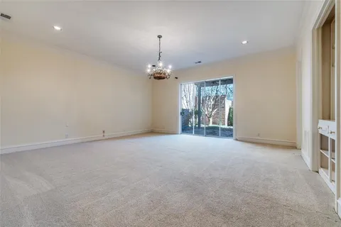 en empty room with windows and chandelier