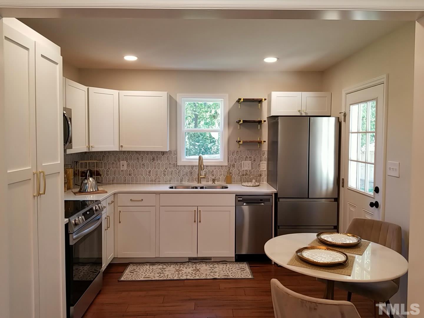 1706 Capps Street Durham, NC 27707 - Photo 11 of 31 a kitchen with stainless steel appliances a sink and a refrigerator