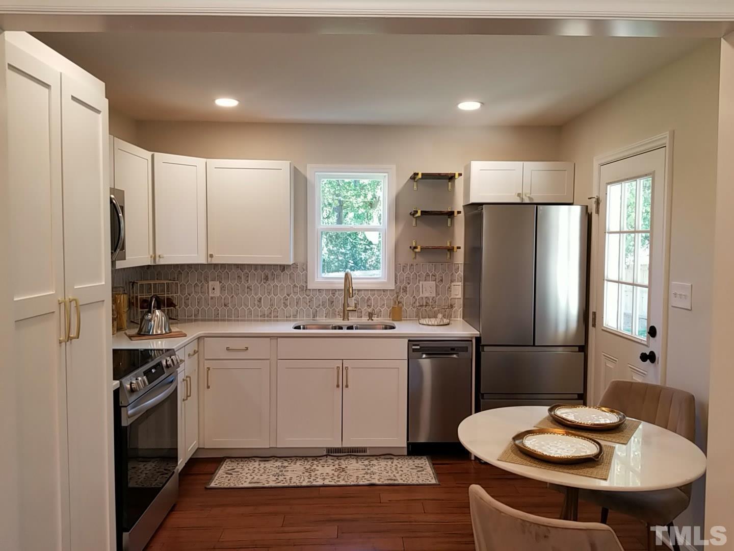 1706 Capps Street Durham, NC 27707 - Photo 13 of 31 a kitchen with stainless steel appliances a sink stove and refrigerator