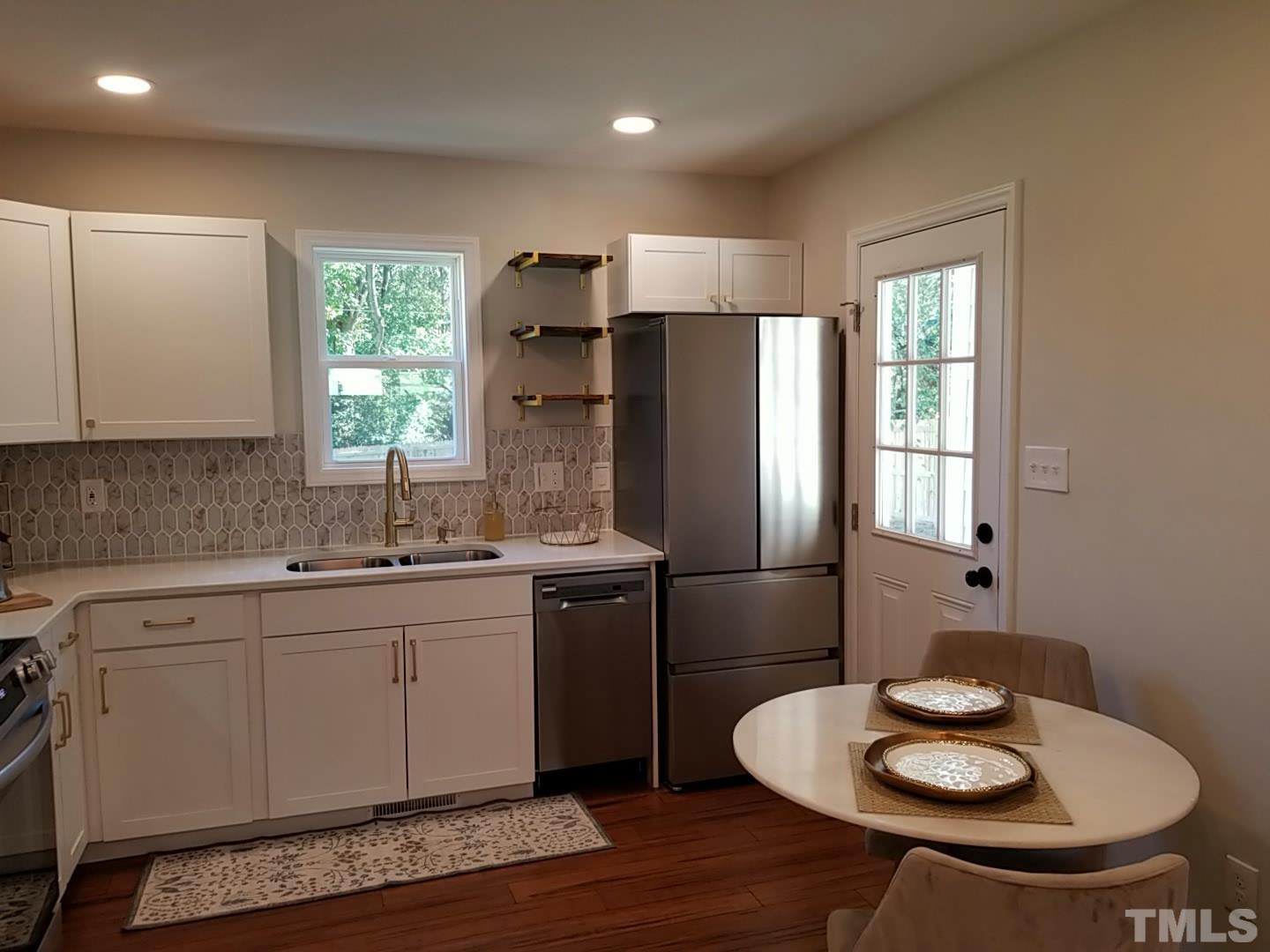 1706 Capps Street Durham, NC 27707 - Photo 14 of 31 a kitchen with stainless steel appliances granite countertop a sink a refrigerator and a stove
