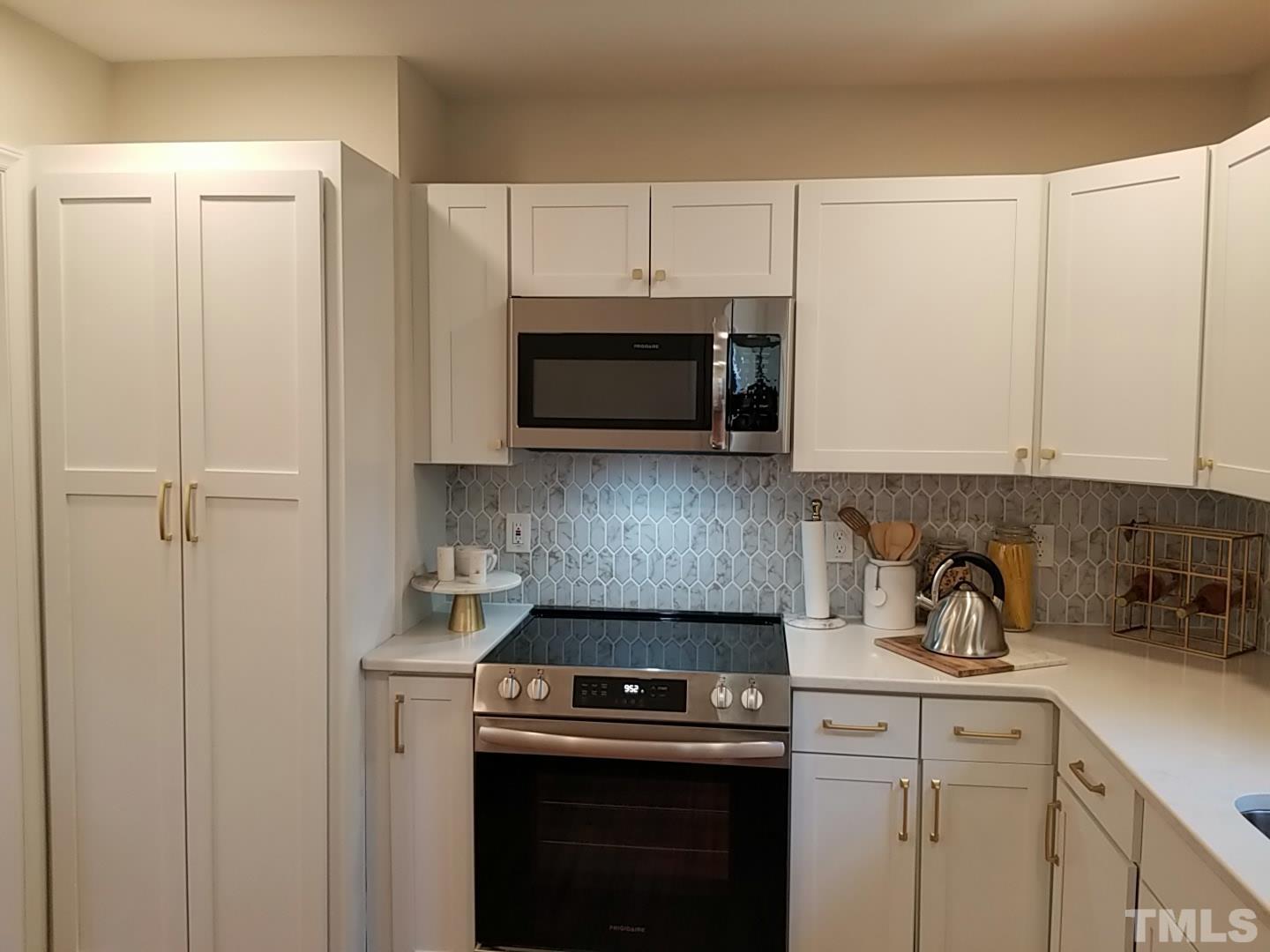 1706 Capps Street Durham, NC 27707 - Photo 15 of 31 a kitchen with stainless steel appliances white cabinets and a stove top oven