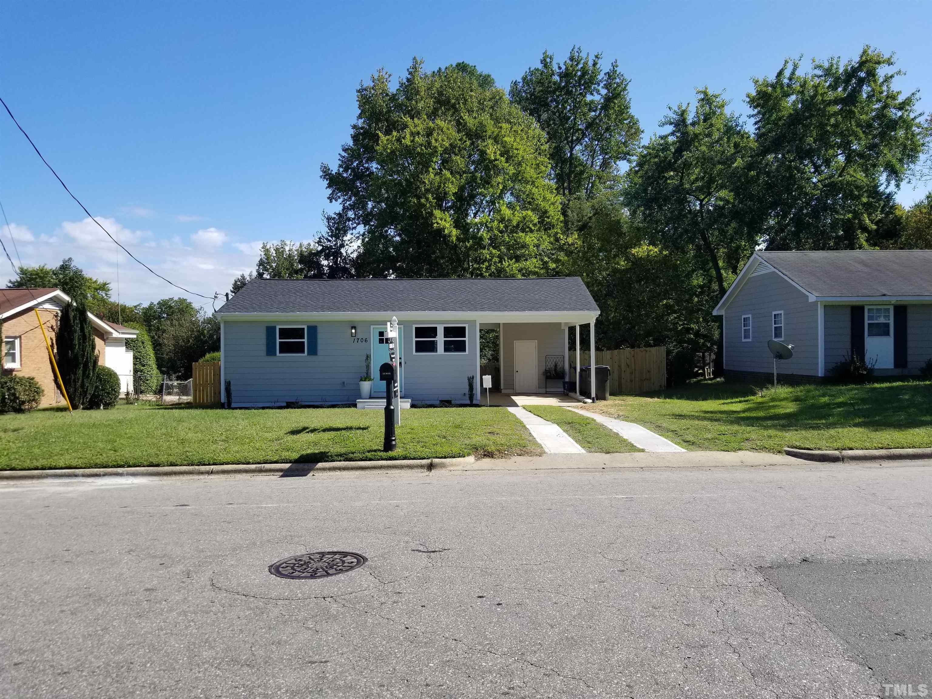 1706 Capps Street Durham, NC 27707 - Photo 2 of 31 a view of yellow house with a yard and large trees
