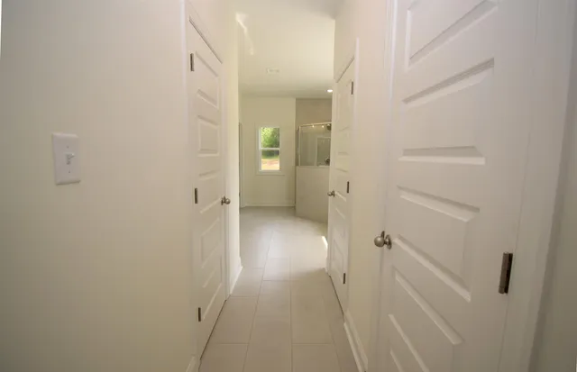 a spacious bathroom with a double vanity sink a large mirror and shower