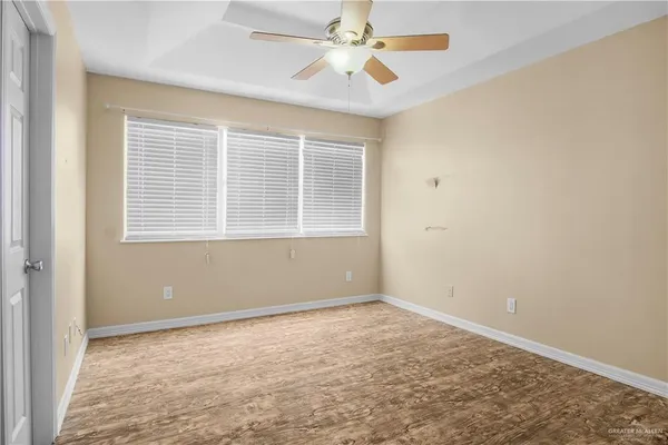 an empty room with a window and a fan
