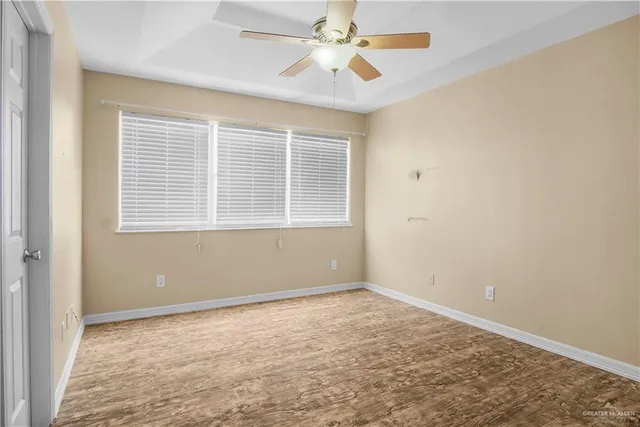 an empty room with a window and a fan