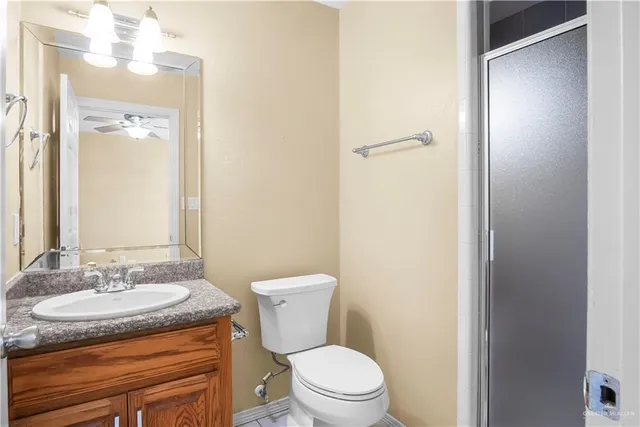 a bathroom with a granite countertop sink toilet and a mirror