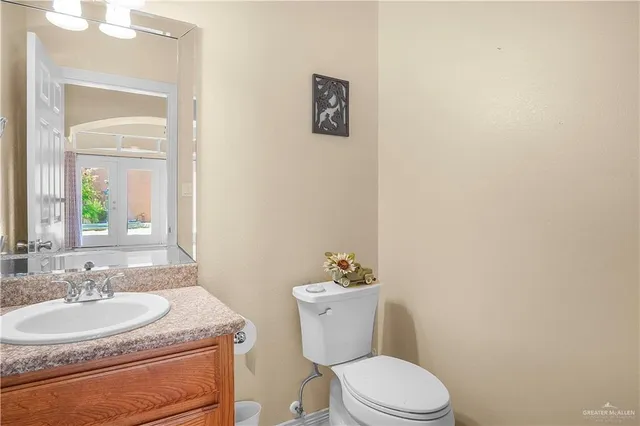 a bathroom with a granite countertop toilet sink and mirror