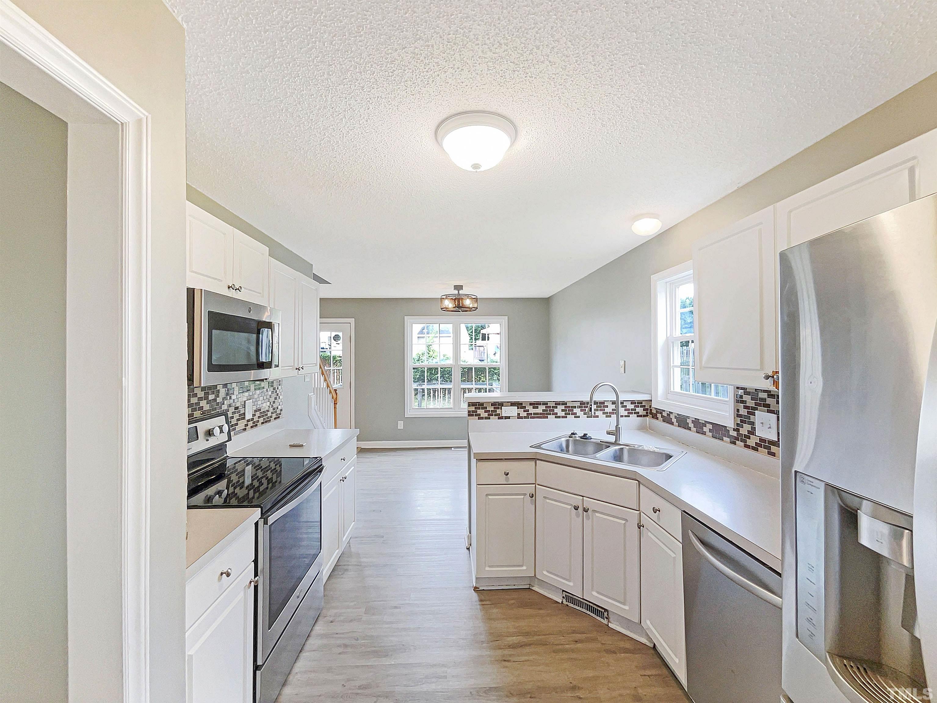 5720 Tealbrook Drive Raleigh, NC 27610 - Photo 2 of 17 a kitchen with a sink stove and refrigerator