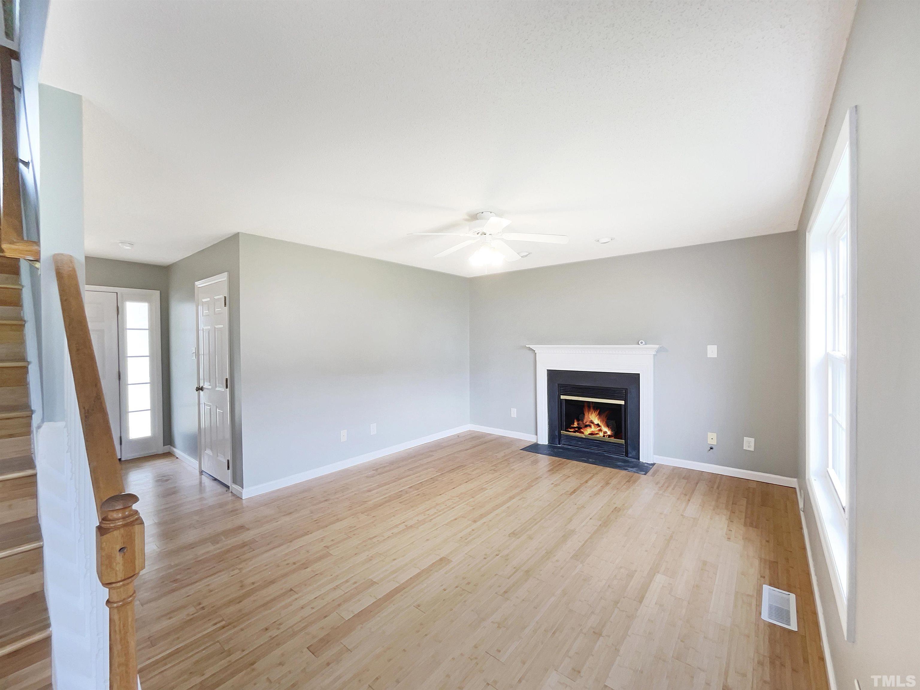5720 Tealbrook Drive Raleigh, NC 27610 - Photo 3 of 17 an empty room with wooden floor and fireplace