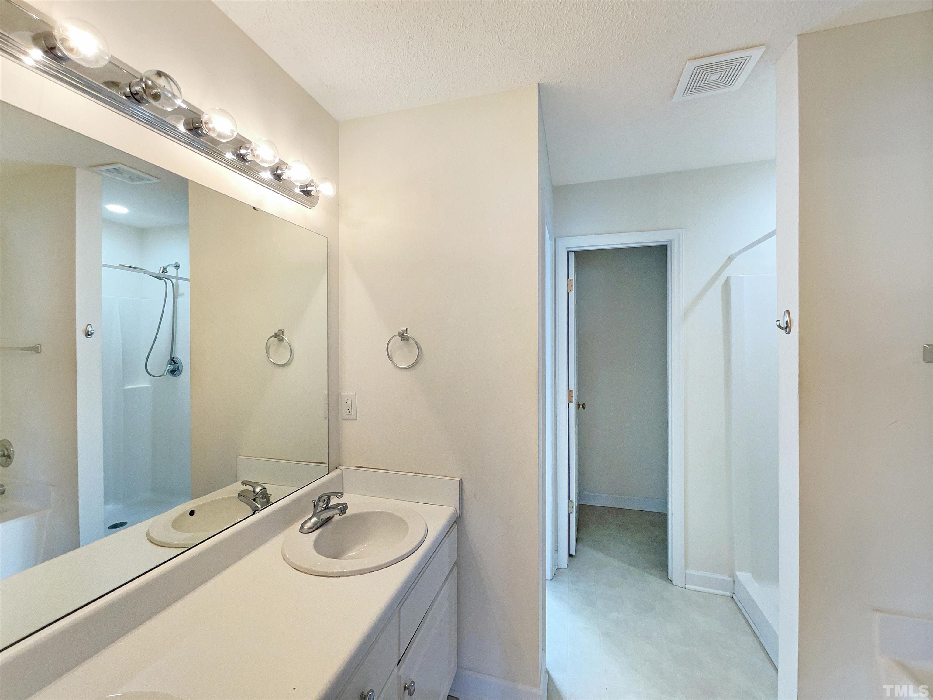 5720 Tealbrook Drive Raleigh, NC 27610 - Photo 4 of 17 a bathroom with a granite countertop sink a mirror a shower and a bathtub