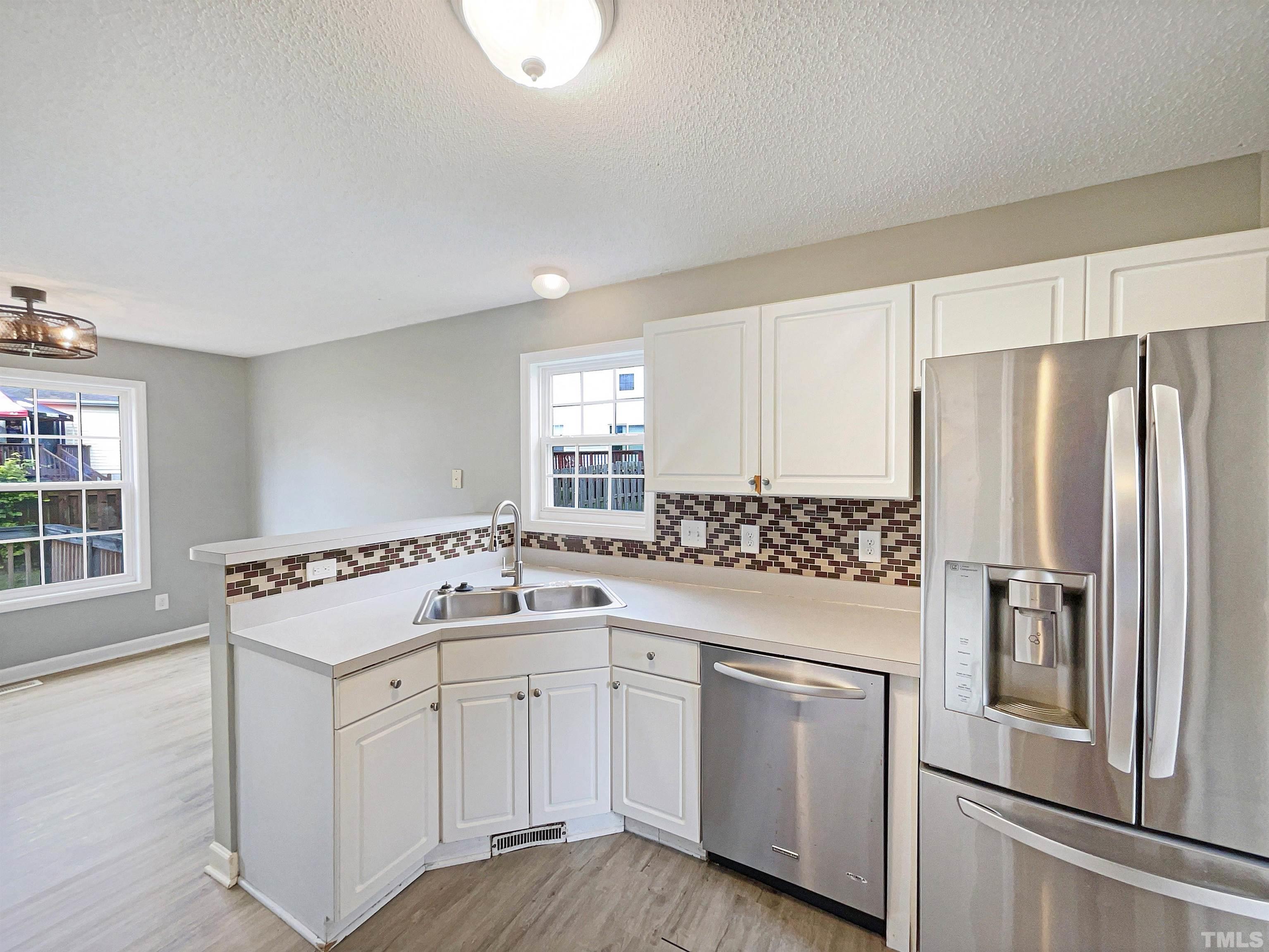 5720 Tealbrook Drive Raleigh, NC 27610 - Photo 6 of 17 a kitchen with white cabinets and white appliances