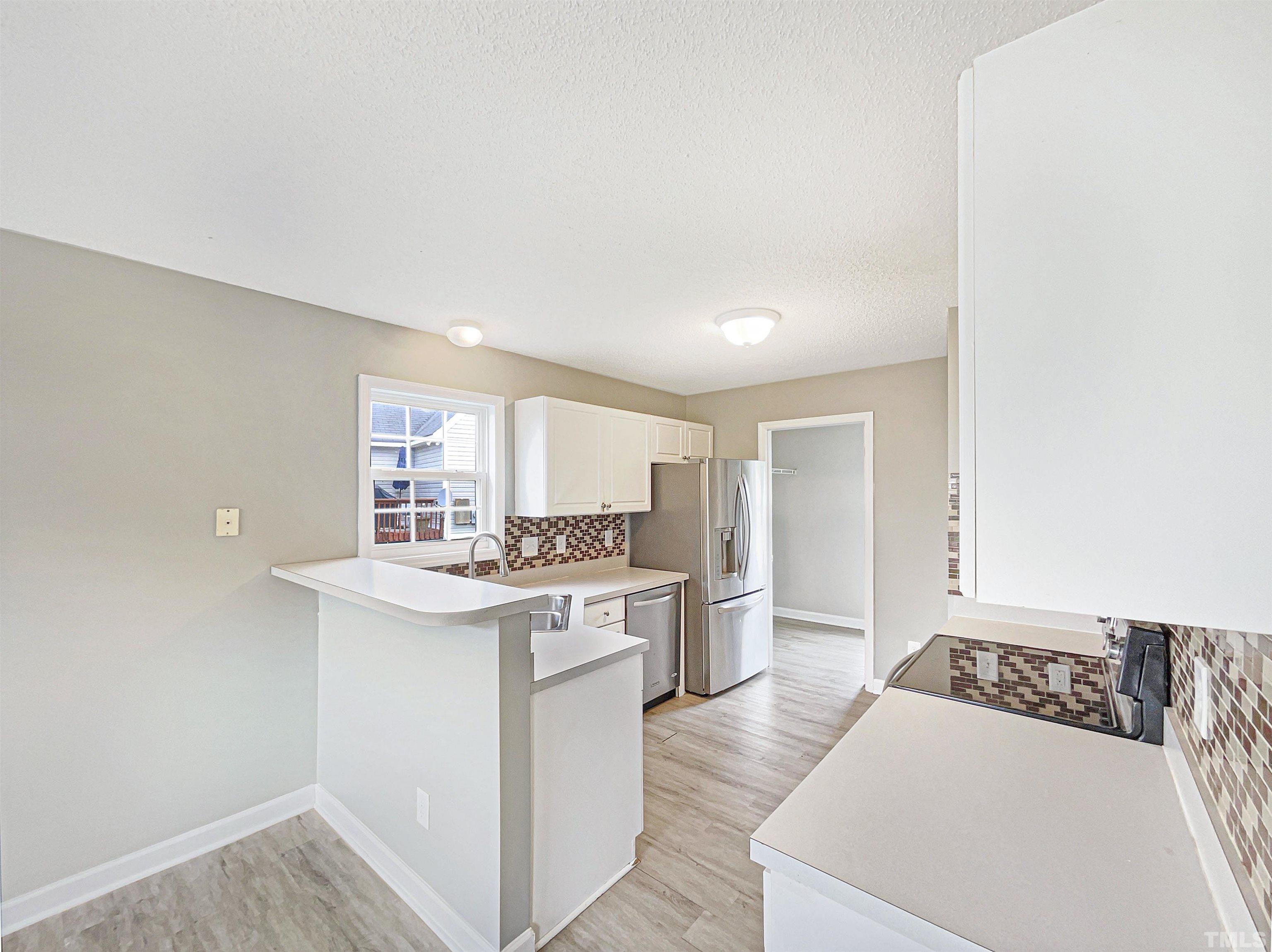 5720 Tealbrook Drive Raleigh, NC 27610 - Photo 7 of 17 a kitchen with a sink stove and cabinets