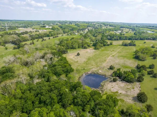 an aerial view of a houses with yard and green space