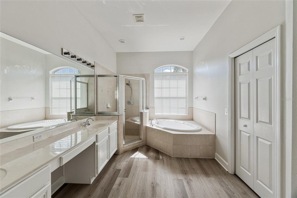 4925 Brightstone Place Spring Hill, FL 34609 - Photo 18 of 40 a bathroom with a double vanity sink a mirror and a bathtub