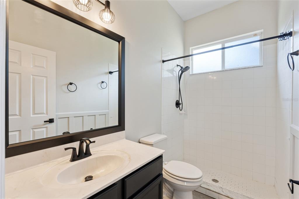 4925 Brightstone Place Spring Hill, FL 34609 - Photo 22 of 40 a bathroom with a sink a toilet a shower and a mirror