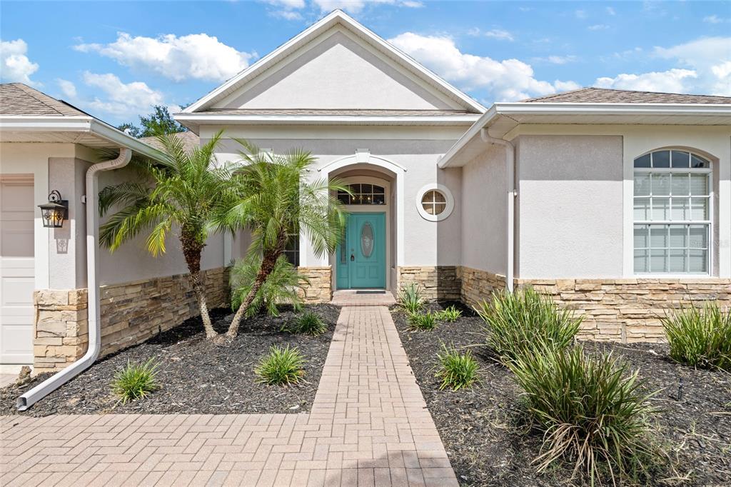 4925 Brightstone Place Spring Hill, FL 34609 - Photo 3 of 40 a front view of a house with garden
