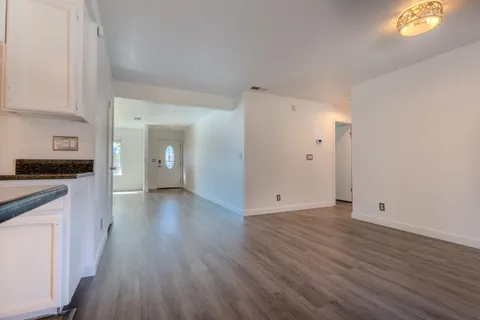 a view of a kitchen with wooden floor and a refrigerator