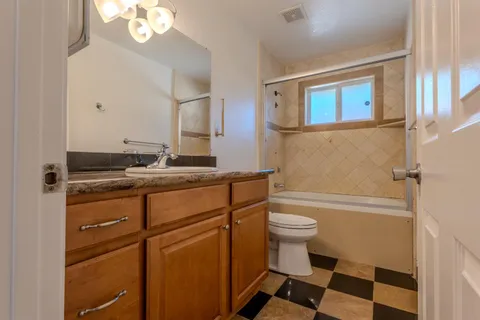 a bathroom with a sink a toilet a mirror and shower