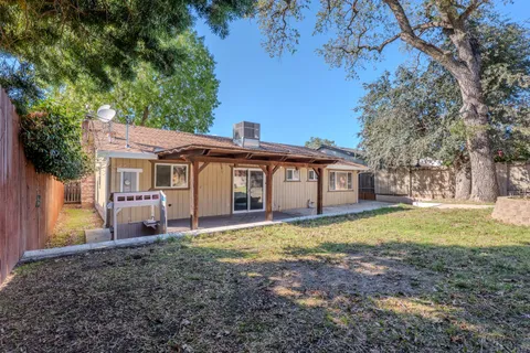 a view of a yard in front of a house with large trees