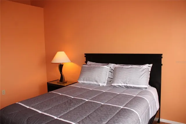 a bed sitting in a bedroom next to a lamp