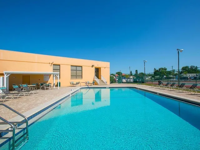 a view of a swimming pool with lawn chairs