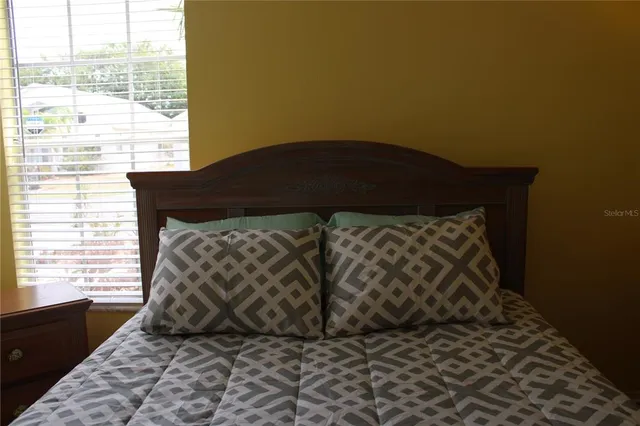a bed sitting in a bedroom next to a window