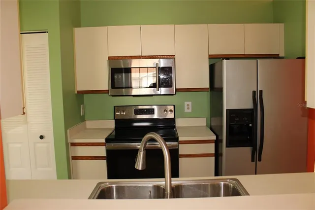 a kitchen with a refrigerator and a sink