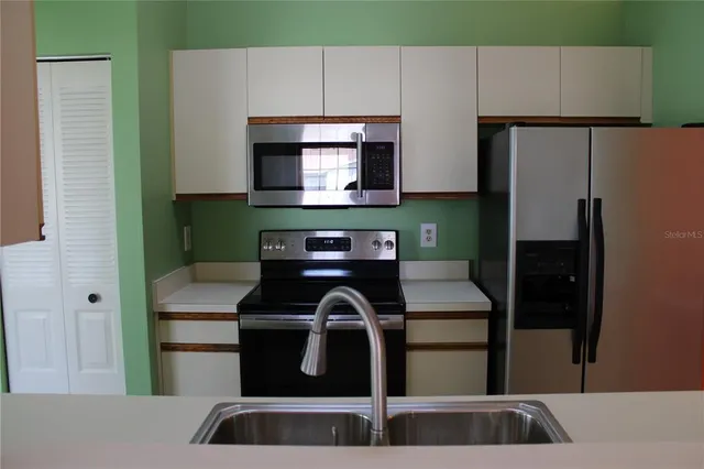 a kitchen with a refrigerator and a sink