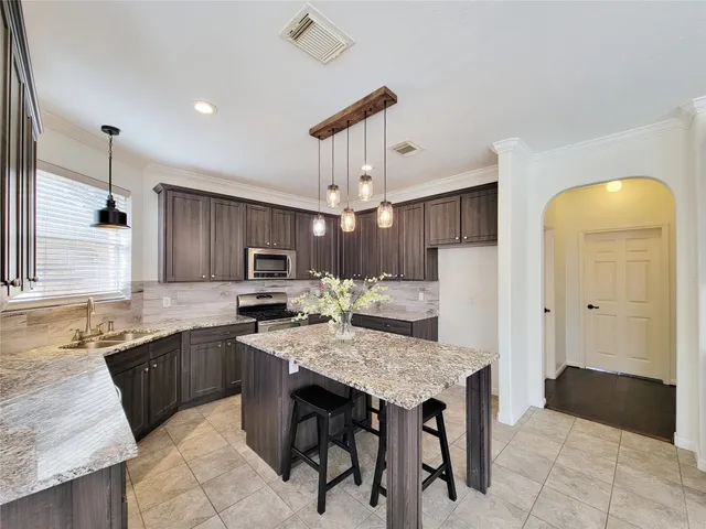 a kitchen with kitchen island granite countertop wooden cabinets a sink and dishwasher